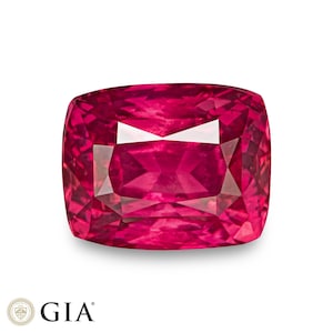 Op de afbeelding: Een levendige, diep rode robijn edelsteen met een kussen-slijp. De edelsteen is gefacetteerd en heeft een hoge glans.