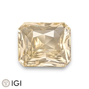 May include: A light yellow, rectangular cut gemstone with a faceted design. The gemstone is set against a white background.