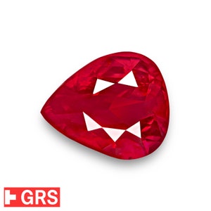 Könnte beinhalten: Ein leuchtend roter birnenförmiger Edelstein mit facettiertem Schliff. Der Edelstein ist vor einem weißen Hintergrund platziert.