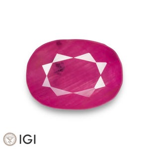 Könnte beinhalten: Ein ovaler Rubin-Edelstein in tiefem Rosa-Rot. Der Stein hat ein sternförmiges Design in der Mitte, das durch weiße Facetten erzeugt wird. Das IGI-Logo ist unten links zu sehen. Auf weißem Hintergrund.