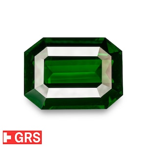 Op de afbeelding: Een rechthoekige smaragdgeslepen edelsteen met een diepgroene kleur. De edelsteen heeft een gefacetteerd oppervlak en een witte rand, tegen een witte achtergrond. Het GRS-logo is linksonder zichtbaar.