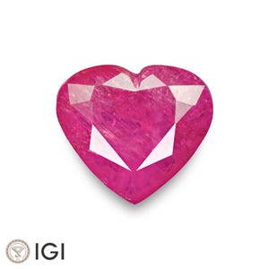 May include: A heart-shaped ruby gemstone with a deep pink hue. The gemstone has a faceted cut and is set in a clear, transparent setting.