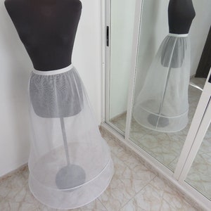 May include: A white tulle petticoat with a satin waistband. The petticoat has two layers of tulle and is designed to add volume to a skirt or dress.