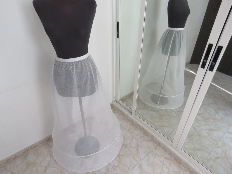 May include: A white tulle petticoat with a satin waistband. The petticoat has two layers of tulle and is designed to add volume to a skirt or dress.