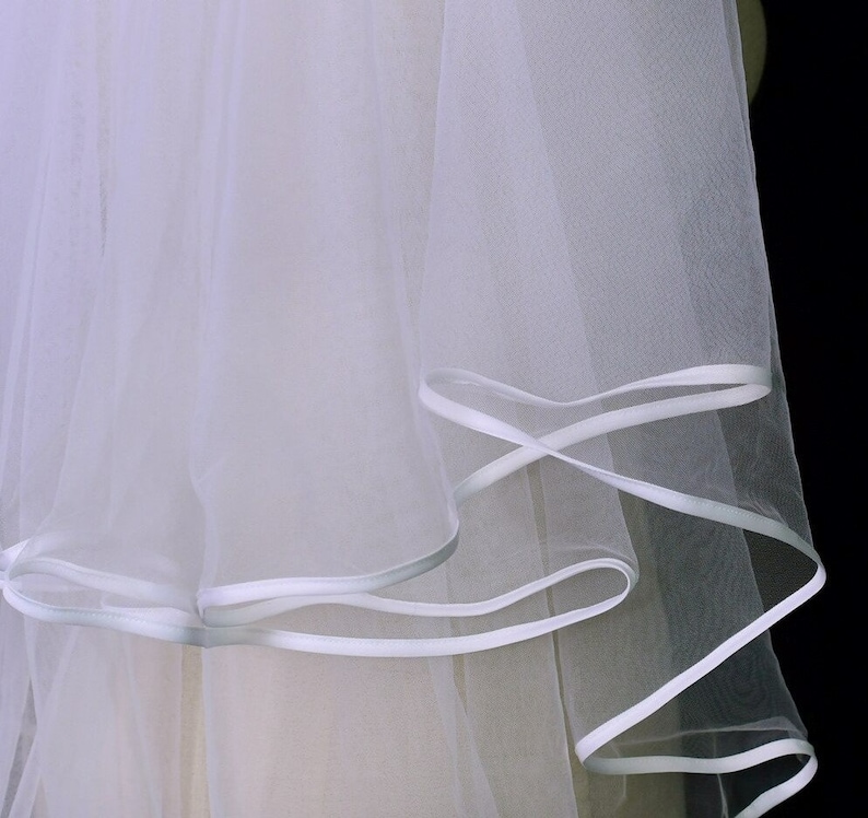 Back view of a long cathedral veil with two layers over a white wedding gown.