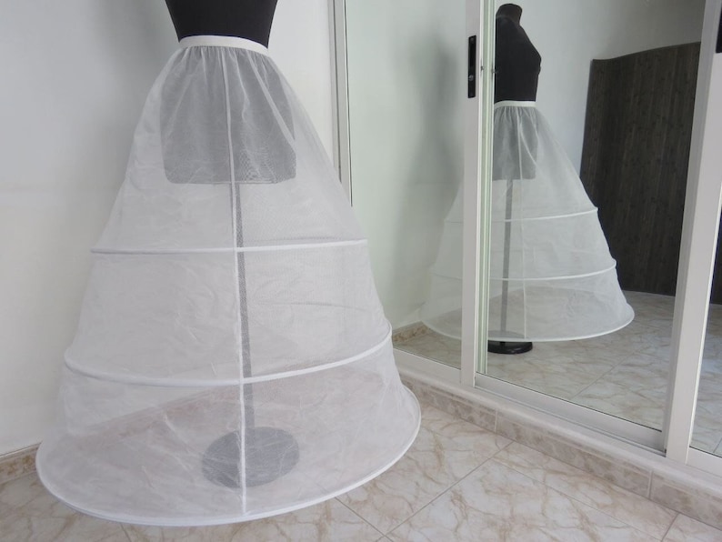 May include: A white tulle petticoat with multiple layers and a white satin waistband. The petticoat is displayed on a white mannequin.