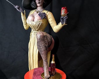 May include: A tall, pale-skinned figurine wearing a wide-brimmed black hat, a yellow dress with a purple flower brooch, and black gloves. One leg is raised, resting on a small red table with a bottle, while holding a cigarette holder and a red goblet.