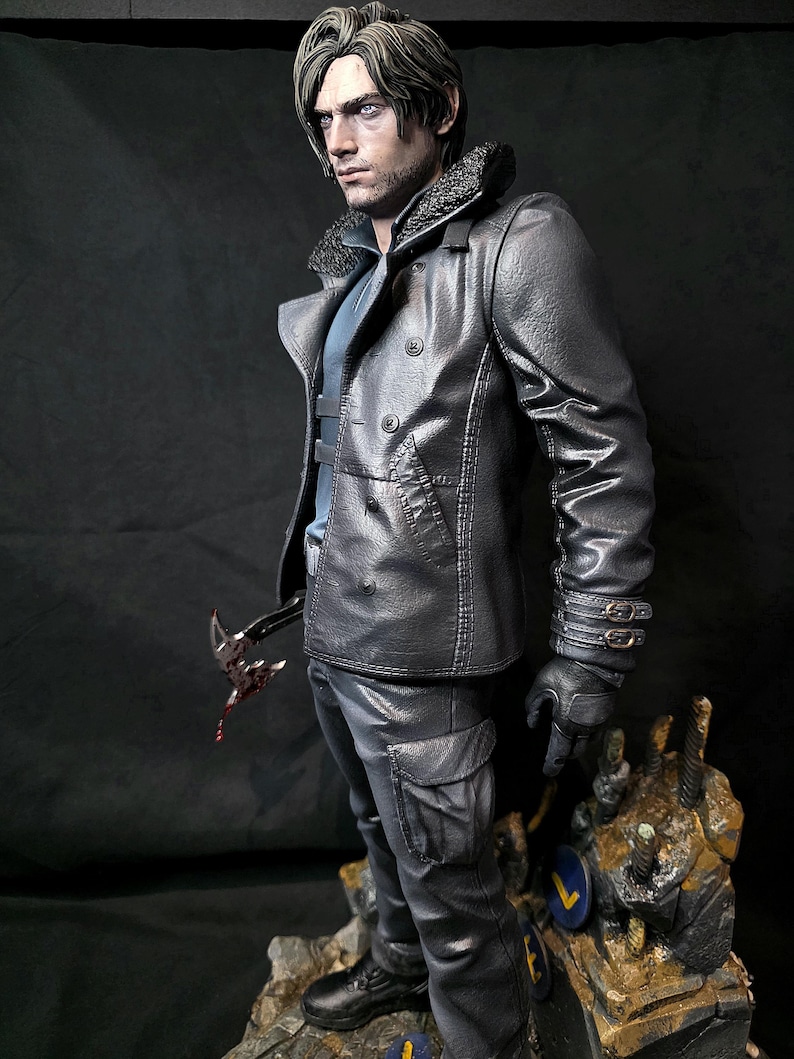 May include: A detailed figurine of a man in a black leather jacket with a fur collar, black gloves, and cargo pants. He holds a bloody weapon. The figure stands on a rocky base with a blue and yellow emblem.