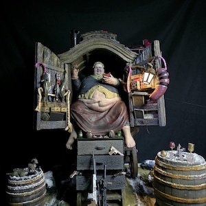 May include: A detailed diorama depicting a seated figure within a wooden structure with open doors. The scene includes barrels, weapons, and miniature items. The figure holds a book. The color palette is muted, with browns, greens, and touches of red.
