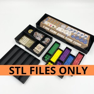 May include: Black board game organizer with multiple compartments holding game pieces, cards, and tokens. The organizer includes various colored wooden blocks and circular tokens. The text "STL FILES ONLY" is displayed on an orange banner.