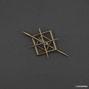 May include: A gold-toned metal brooch featuring a square frame intersected by two long, pointed needle-like bars that extend beyond the edges. The design creates a geometric, star-like composition with a central open space and sharp, tapered ends.