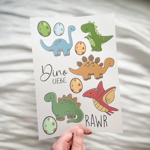 Könnte beinhalten: Ein Bogen mit Aufklebern zum Thema Dinosaurier, mit verschiedenen Cartoon-Dinosauriern in Blau, Grün und Orange sowie Eiern. Der Text "Dino Liebe" und "RAWR" ist ebenfalls enthalten.