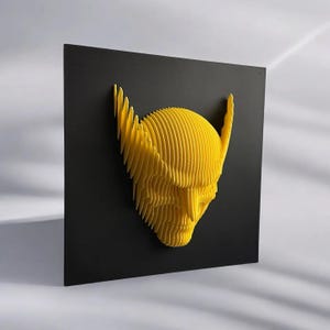 May include: A yellow 3D printed sculpture of a face with horns, mounted on a black background.