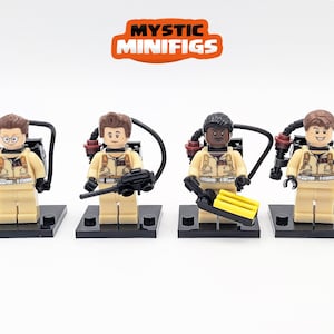 Peut inclure: Quatre figurines Ghostbusters, chacune portant une combinaison beige, un sac à dos à protons et un fusil à protons noir et gris. Les figurines sont sur des socles noirs. Les figurines sont issues de la franchise de films Ghostbusters.