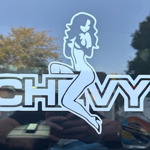 May include: A white vinyl decal with a silhouette of a woman sitting on the word "CHVY".