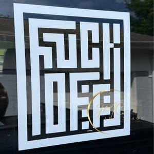 May include: White and black square graphic with the words "FUCK OFF" in a bold, geometric font. The design is displayed on a window, with a gold-colored logo in the lower right corner.