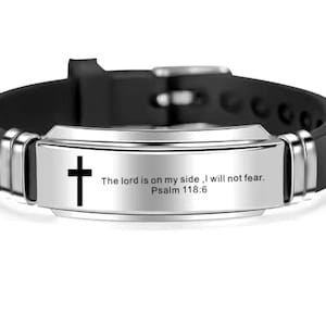 May include: A black silicone bracelet with a silver metal plate featuring a cross and the inscription "The lord is on my side, I will not fear. Psalm 118:6".