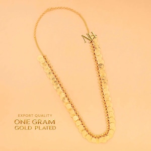 May include: Gold-plated necklace with a coin design. The necklace features a series of small, round, gold-colored coins linked together, with a delicate chain at the top. The text "EXPORT QUALITY ONE GRAM GOLD PLATED" is visible.