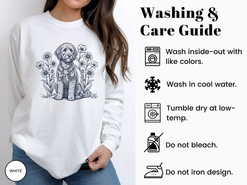 Pode incluir: Camisola branca com uma ilustra&ccedil;&atilde;o a preto e branco de um c&atilde;o rodeado por flores. A parte superior de manga comprida tem gola redonda. A imagem tamb&eacute;m inclui um guia de lavagem e cuidados.