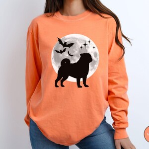 K&ouml;nnte beinhalten: Orangefarbenes Langarmshirt mit schwarzer Silhouette einer Mops vor einem Vollmond und Flederm&auml;usen. Das Shirt hat einen Rundhalsausschnitt und ist aus weichem Material. Die Farbe des Shirts ist Melone.
