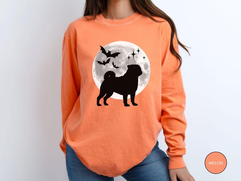 K&ouml;nnte beinhalten: Orangefarbenes Langarmshirt mit schwarzer Silhouette einer Mops vor einem Vollmond und Flederm&auml;usen. Das Shirt hat einen Rundhalsausschnitt und ist aus weichem Material. Die Farbe des Shirts ist Melone.