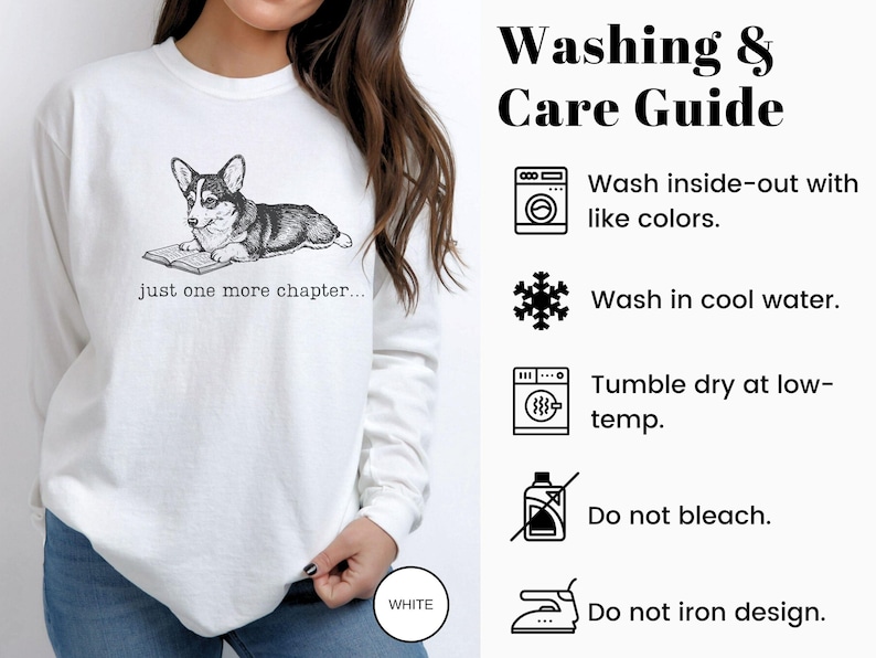 Op de afbeelding: Witte sweatshirt met een zwart-wit illustratie van een Corgi hond die een boek leest, met de tekst "just one more chapter...". De was- en verzorgingsgids staat aan de rechterkant.