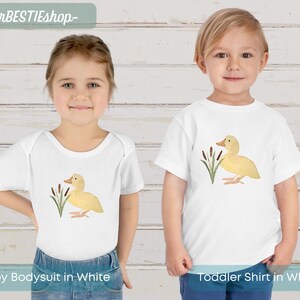 May include: White baby bodysuit and toddler shirt with a yellow duckling illustration and green reeds. The text "yourBESTIEshop" is at the top of the image.