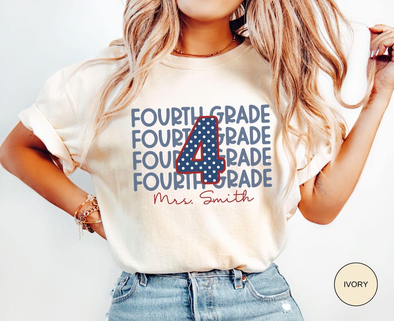 May include: An ivory short-sleeve t-shirt featuring the text "FOURTH GRADE" repeated four times in blue, with a large central number "4" in blue with white polka dots and a red outline, and the name "Mrs. Smith" in red cursive script below.