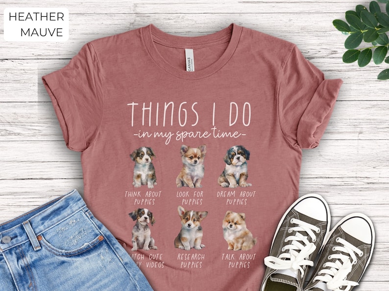 Op de afbeelding: Heather mauve t-shirt met de tekst "THINGS I DO - in my spare time-" en illustraties van puppy's. Het shirt zegt ook "THINK ABOUT PUPPIES", "LOOK FOR PUPPIES", "DREAM ABOUT PUPPIES", "WATCH CUTE PUPPY VIDEOS", "RESEARCH PUPPIES" en "TALK ABOUT PUPPIES".