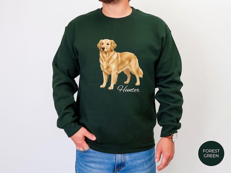 May include: Forest green sweatshirt featuring a golden retriever illustration. The dog is standing, with the name "Hunter" in script below. The sweatshirt is a solid color, with a crew neck and long sleeves.