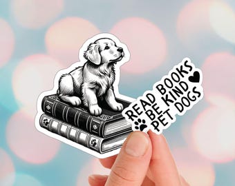 Peut inclure: Autocollant noir et blanc d'un chiot golden retriever assis sur une pile de livres. L'autocollant porte le texte "Read Books Be Kind Pet Dogs" avec un symbole de cœur.