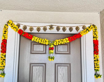 May include: A traditional Indian door garland made of artificial yellow and red flowers with a gold chain and decorative charms hanging above.