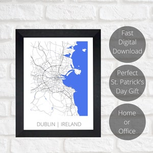 May include: A black and white map of Dublin, Ireland, with a blue outline of the city and surrounding water. The map is framed in a black frame and is hanging on a white brick wall. The text "DUBLIN | IRELAND" is printed below the map. The text "Fast Digital Download", "Perfect St. Patrick's Day Gift", and "Home or Office" is printed in circles on the right side of the image.