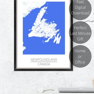 May include: A framed print of a blue map of Newfoundland, Canada. The map is white and shows the outline of the island. The text "NEWFOUNDLAND CANADA" is printed below the map.