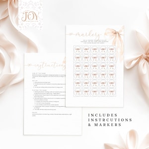 May include: A printable bingo game with instructions and markers. The game features a pink and white bow design with the words "The Joy Emporium" and "Markers" in gold lettering.
