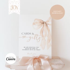 May include: A printable sign with a watercolour illustration of a pink ribbon bow. The sign reads "Cards & gifts" and "We are grateful you could be here to celebrate with us today. Thank you."