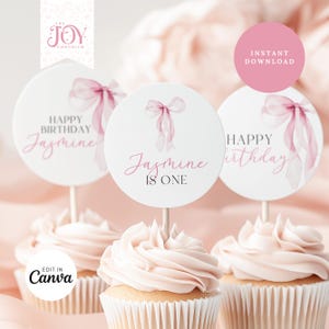 Op de afbeelding: Drie roze en witte cupcake-toppers met een roze aquarel-boogsjabloon. De toppers zeggen "Happy Birthday Jasmine", "Jasmine is One" en "Happy Birthday".