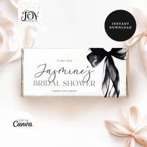 Peut inclure: Une enveloppe de barre de chocolat blanche avec un design de nœud en ruban noir et blanc. Le texte sur l'enveloppe indique "23 mai 2025 Le shower nuptial de Jasmine Merci de votre présence".