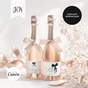 Puede incluir: Dos botellas de champán con líquido rosa, tapas de papel de plata plateadas y lazos color crema. Cada botella tiene una etiqueta blanca con texto negro y un gráfico de lazo. Una etiqueta dice "cheers Mrs. Smith", la otra dice "pop & cheer". La imagen incluye el texto "Instant Download" y "Edit in Canva".