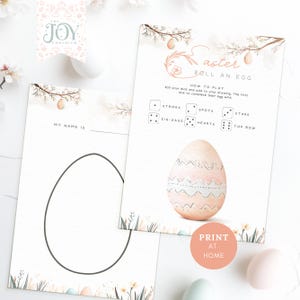Puede incluir: Hojas de juego imprimibles con temática de Pascua. Una hoja presenta un contorno de huevo para dibujar, la otra tiene instrucciones para "Roll an Egg" con símbolos de dados y un huevo ilustrado. El logotipo de The Joy Emporium es visible.