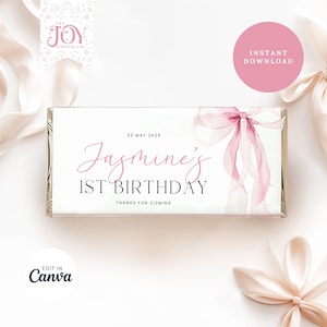 以下が含まれることがあります： ピンクの水彩画のリボンと「Jasmine's 1st Birthday」と「23 May 2025」のテキストが書かれた、印刷可能なチョコレートバーのラッパーです。