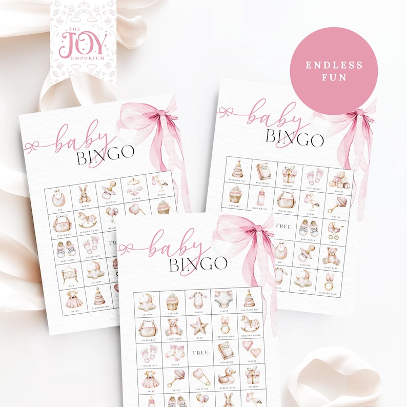 May include: Three pink and white baby bingo cards with a pink ribbon and bow on each card. The cards have images of baby items such as a rattle, a bib, a stuffed animal, a rocking horse, a baby bottle, a cupcake, a diaper, a baby shoe, a pacifier, a teddy bear, a star, a teething ring, a book, a heart, a duck, a gift box, a crown, a rattle, a safety pin, a bunny, and a crib.
