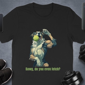 Może przedstawiać: Czarny t-shirt z kreskówkowym psem napinającym biceps trzymającym piłkę tenisową. Tekst na koszulce brzmi "Dawg, do you even fetch?" w kolorze zielonym. Pies jest biały, niebieski i brązowy.
