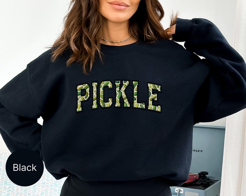 a woman wearing a black sweatshirt with the word pickle printed on it