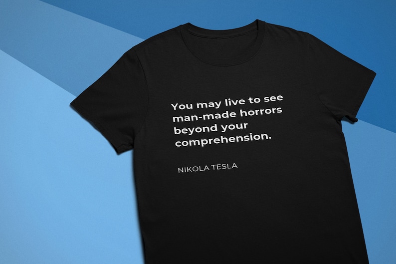 May include: Black t-shirt with white text that reads "You may live to see man-made horrors beyond your comprehension." and "NIKOLA TESLA" at the bottom.