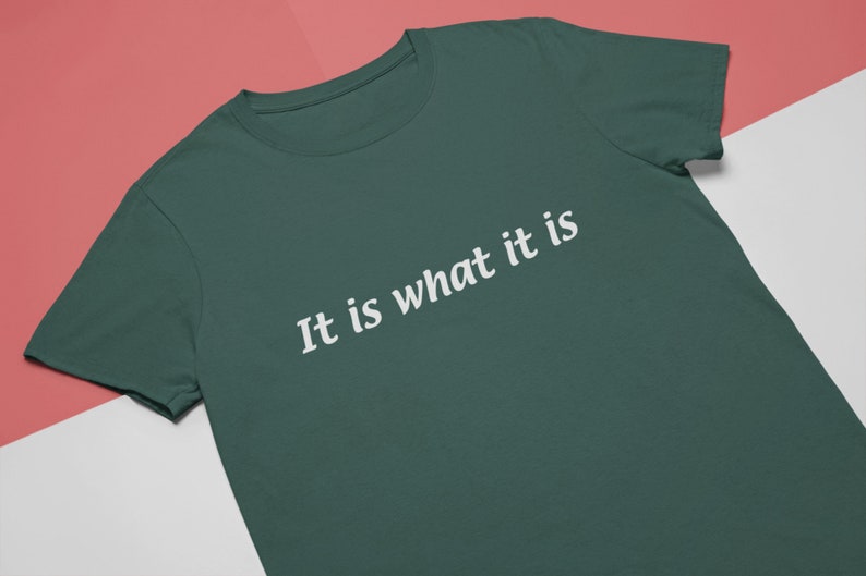 K&ouml;nnte beinhalten: Ein dunkelgr&uuml;nes T-Shirt mit dem Aufdruck "It is what it is" in wei&szlig;.
