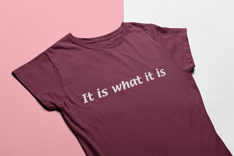 K&ouml;nnte beinhalten: Ein maroonfarbenes T-Shirt mit dem Aufdruck "It is what it is" in wei&szlig;.