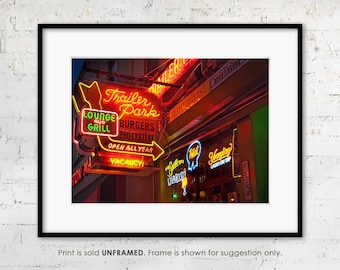 May include: A framed print featuring vibrant neon signs for a bar or restaurant. The signs advertise "Trailer Park Lounge and Grill," "Burgers," and "Phillysteak." Other signs include "Margaritas" and "Lager on Tap."