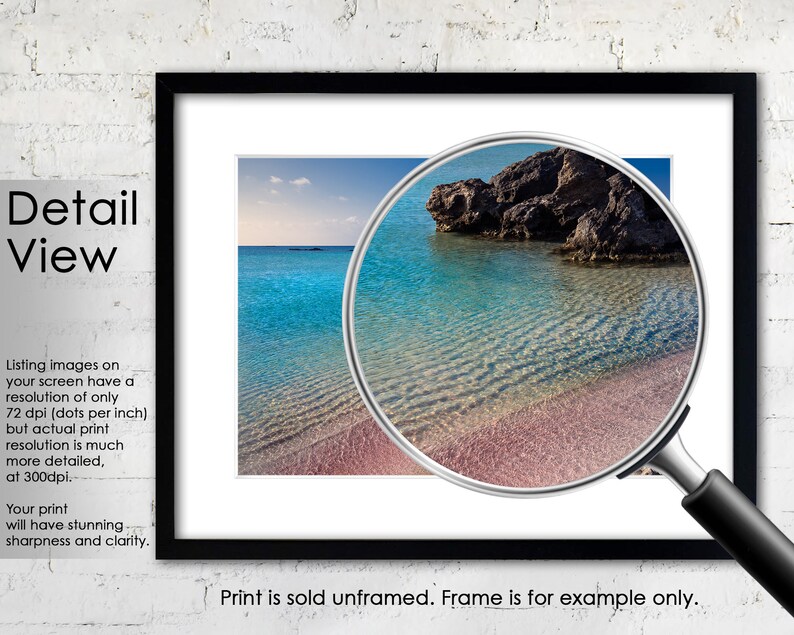 May include: A close-up of a beach with clear turquoise water and a rocky outcrop. The water is shallow and the sand is pink. The image is framed with a black frame and a magnifying glass is over the image.