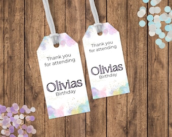 May include: Two watercolor-style gift tags with the text "Thank you for attending Olivias Birthday" on a wooden background with confetti.